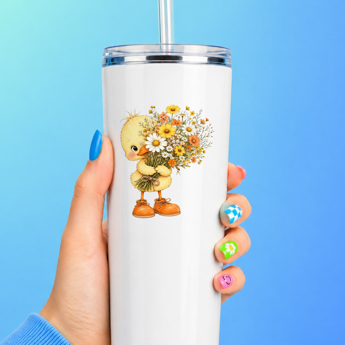 Baby Duck Holding Wildflower Bouquet UV DTF sticker applied to a white straw tumbler on a blue background