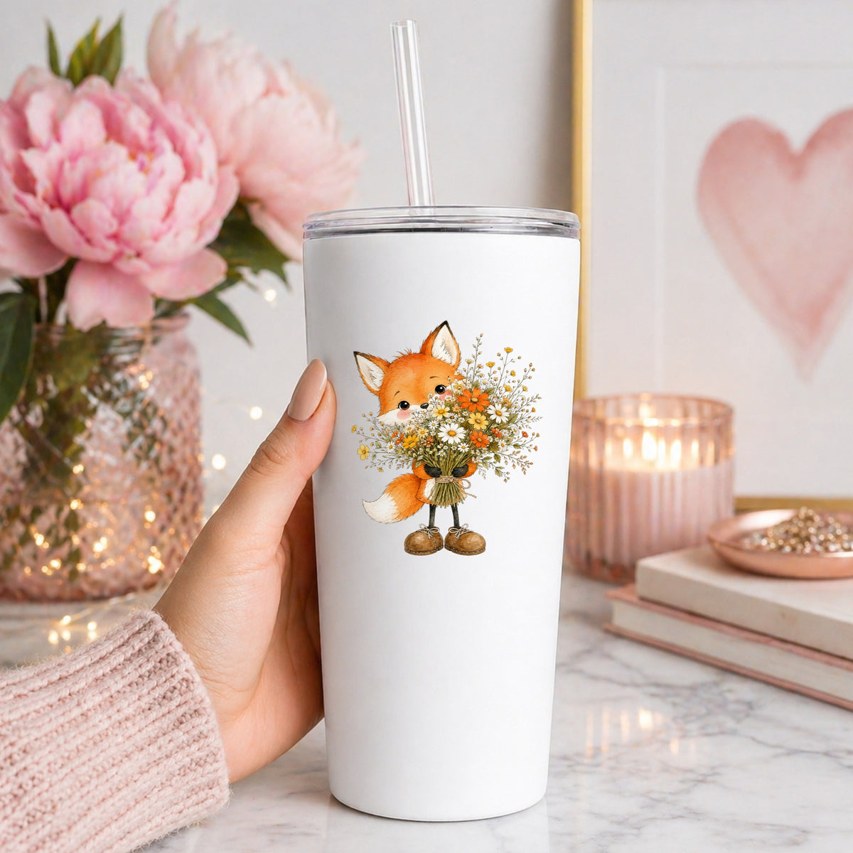 Orange Fox Holding Flower Bouquet UV DTF sticker applied to a white straw tumbler beside pink peonies