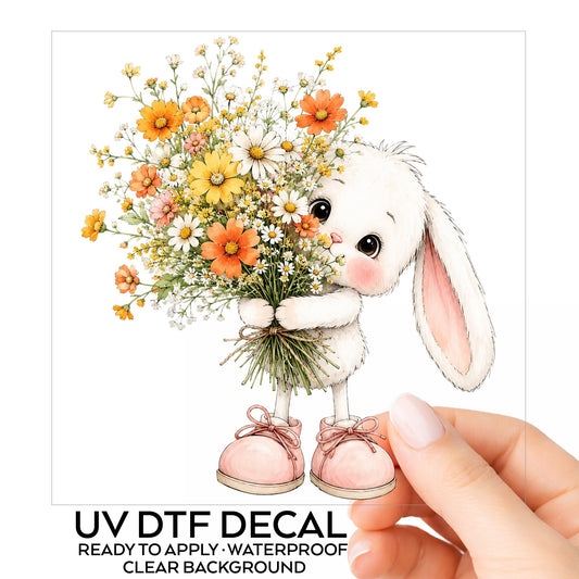Baby Bunny Holding Daisy Bouquet UV DTF sticker on its backing card, held in hand