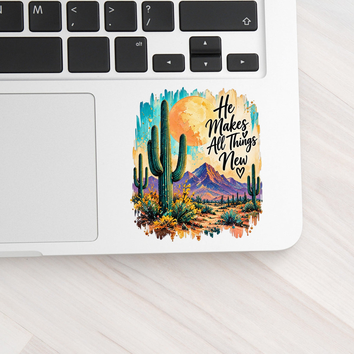 He Makes All Things New desert cactus UV DTF sticker on a laptop keyboard