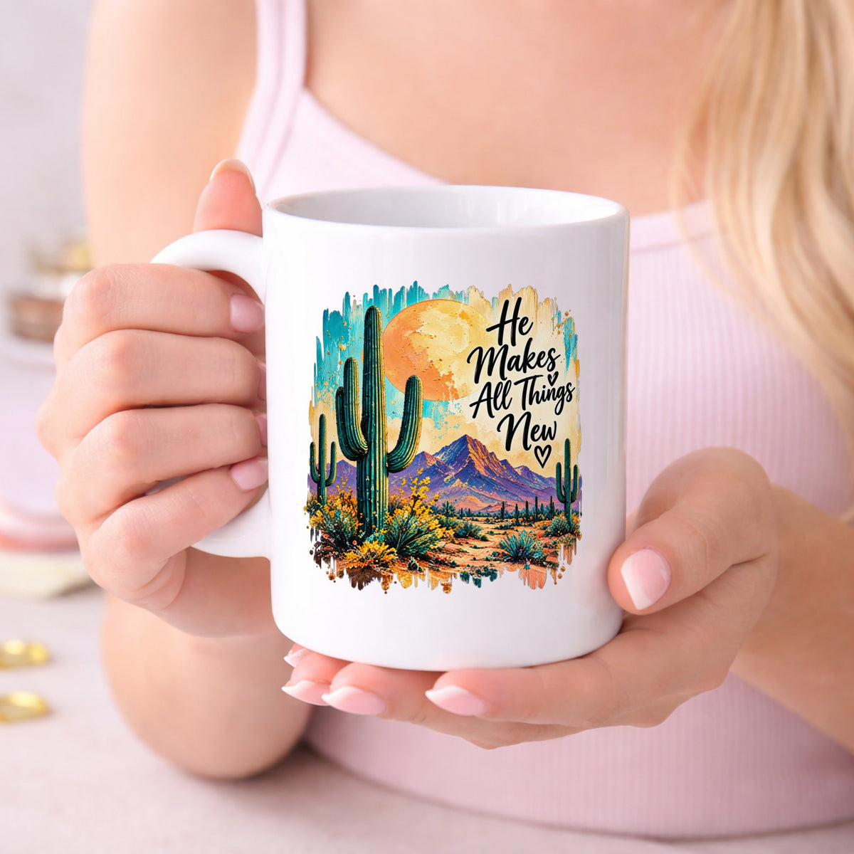 He Makes All Things New desert cactus UV DTF sticker held beside a white coffee cup