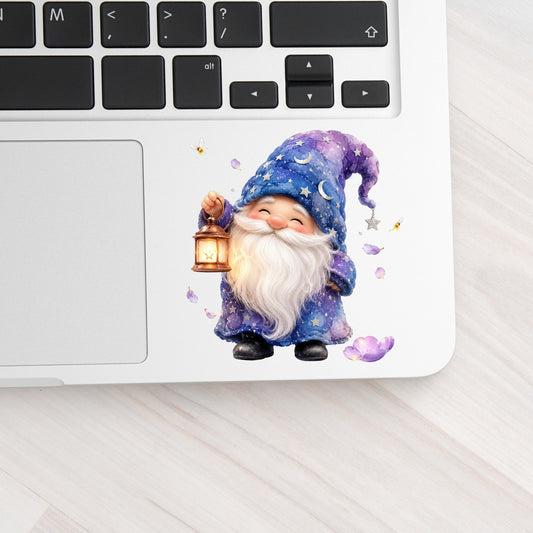 Gnome Holding A Lantern UV DTF sticker applied to a silver laptop beside the keyboard