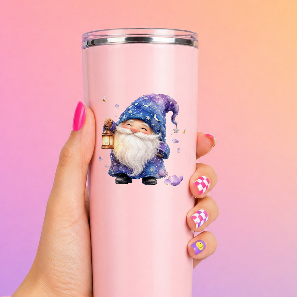 Gnome Holding A Lantern UV DTF sticker applied to a tall pink tumbler on a pink and orange background