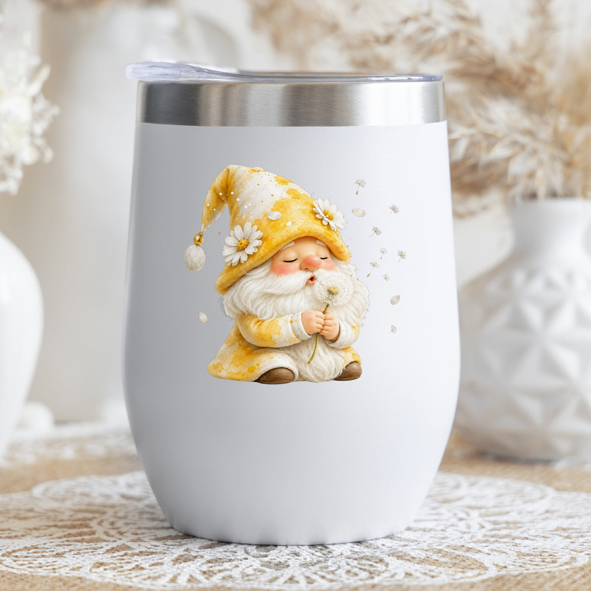 Gnome Blowing A Dandelion UV DTF sticker applied to a white stemless tumbler with a lid