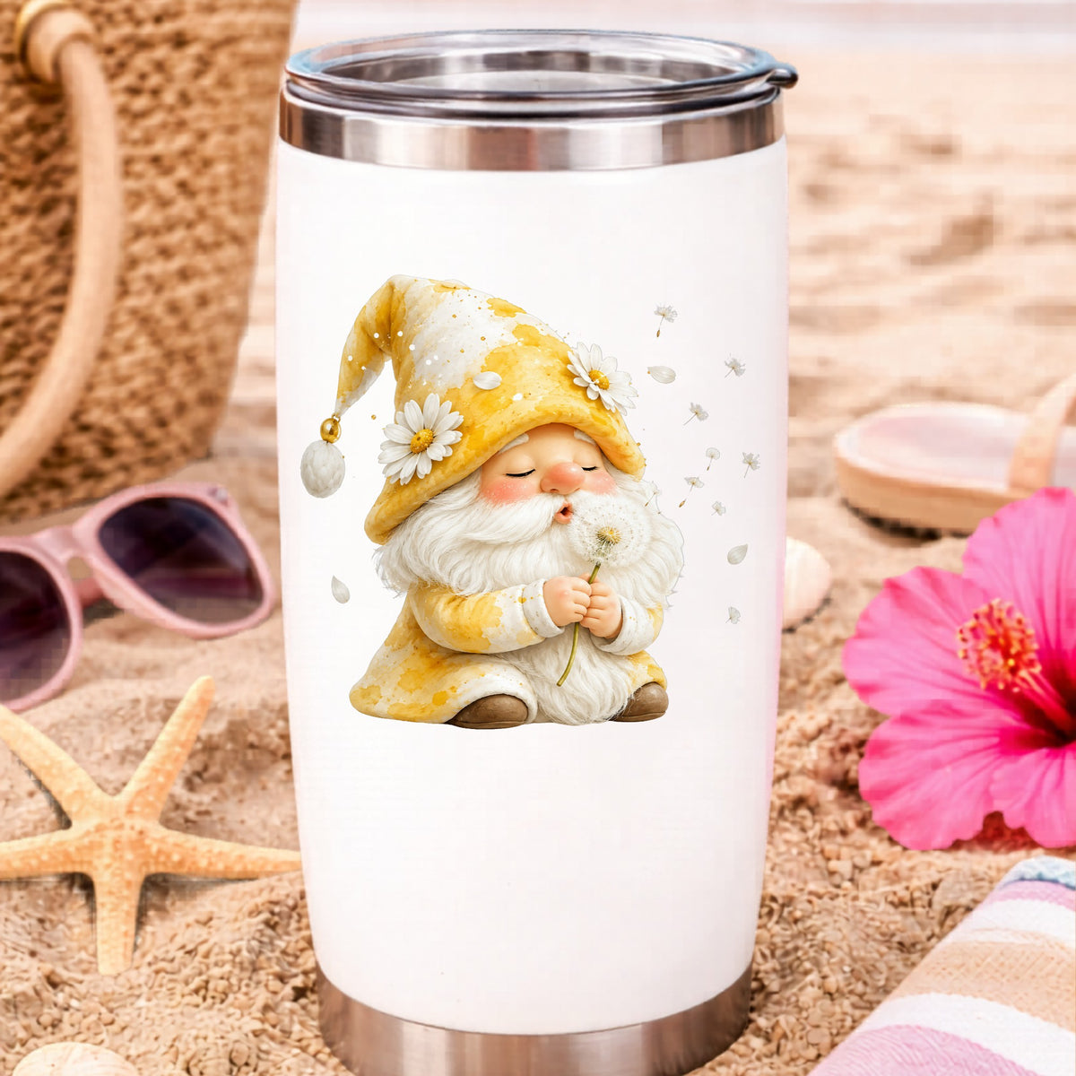 Gnome Blowing A Dandelion UV DTF sticker applied to a white travel tumbler on beach sand