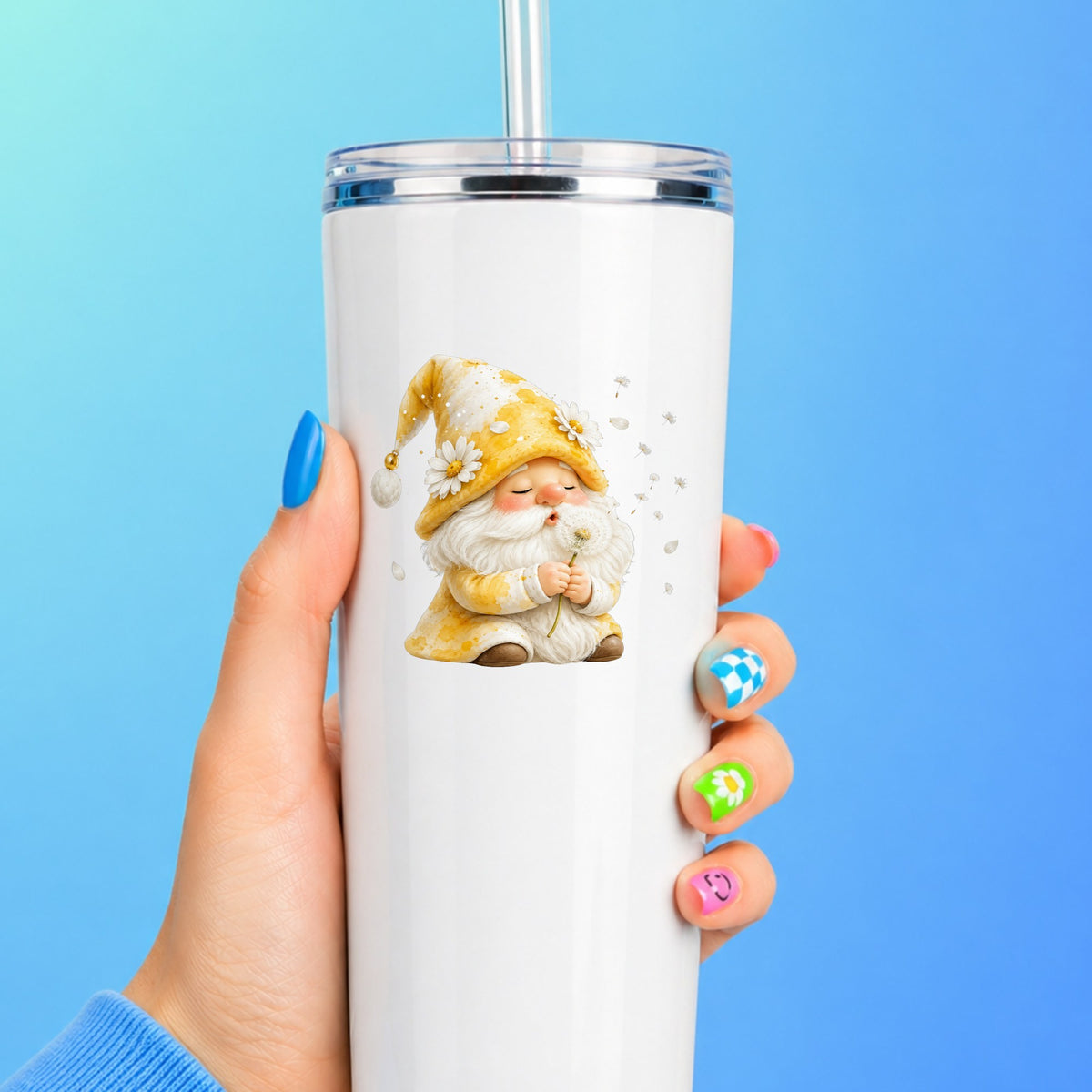 Gnome Blowing A Dandelion UV DTF sticker applied to a white straw tumbler on a blue background