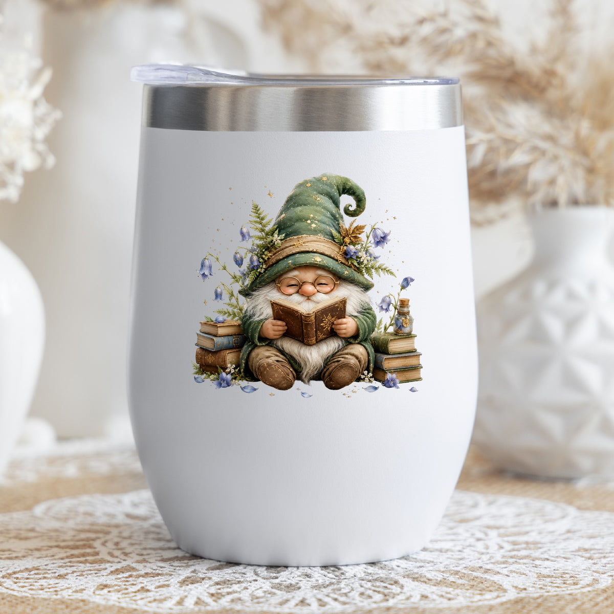 Gnome Reading With Book Stack UV DTF sticker applied to a white stemless tumbler with a lid