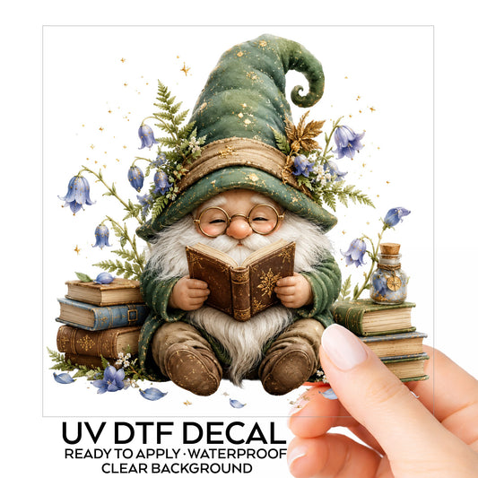 Gnome Reading With Book Stack UV DTF sticker on its backing card, held in hand