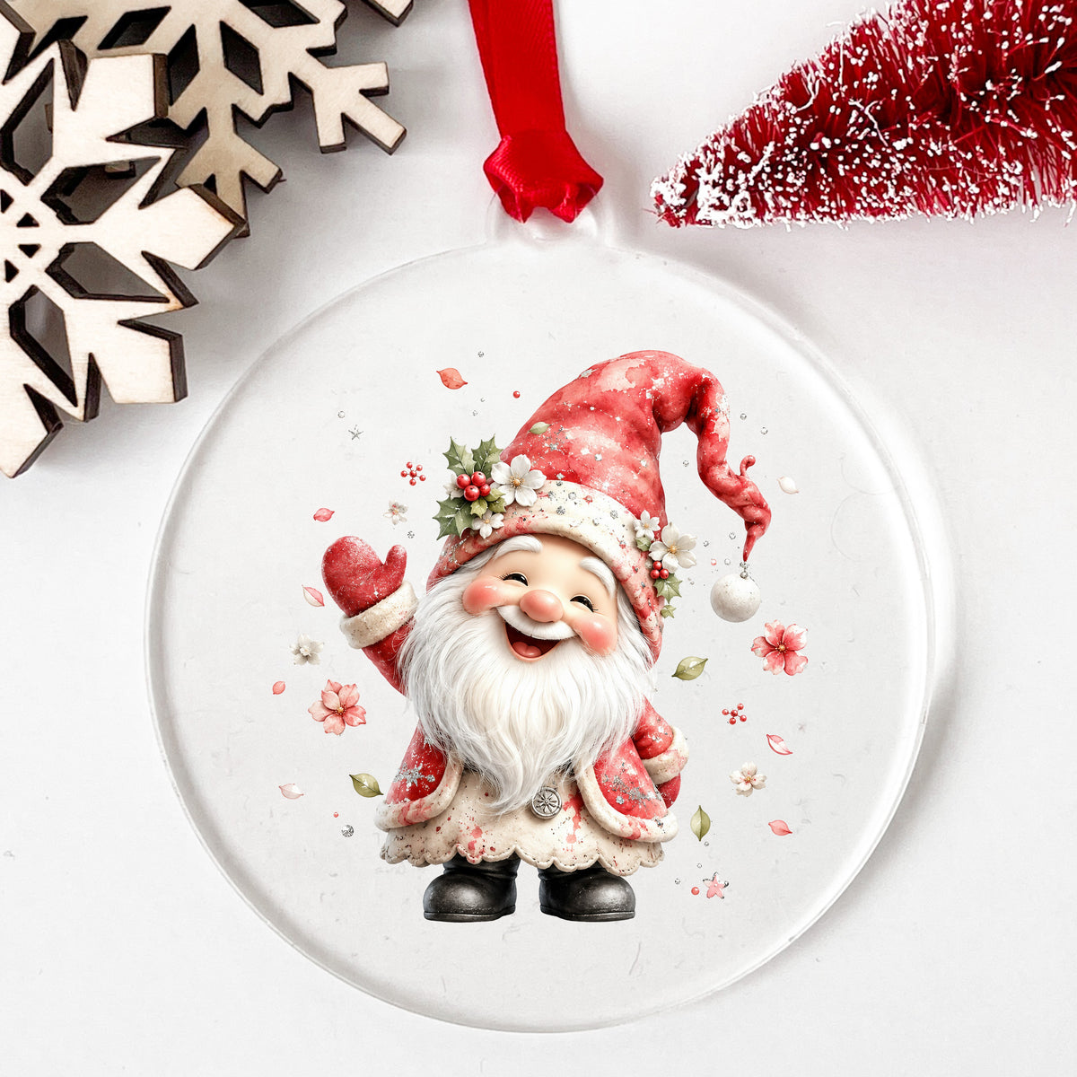Red Christmas Gnome UV DTF sticker applied to a clear round acrylic ornament with a red ribbon