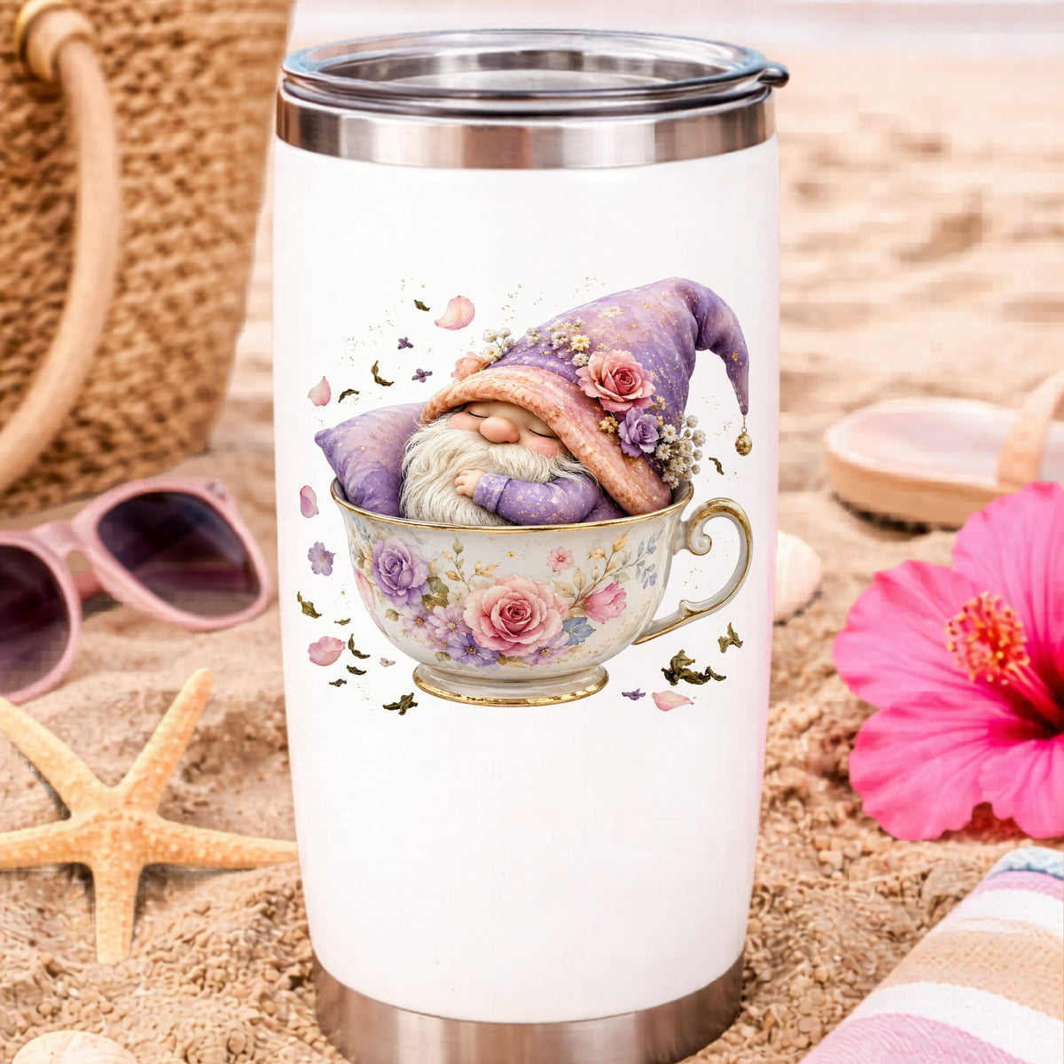 Gnome Sleeping In Teacup UV DTF sticker applied to a white travel tumbler on beach sand