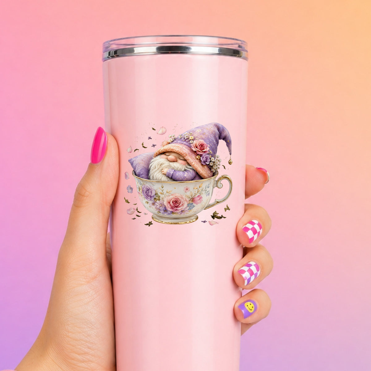 Gnome Sleeping In Teacup UV DTF sticker applied to a tall pink tumbler on a pink and orange background
