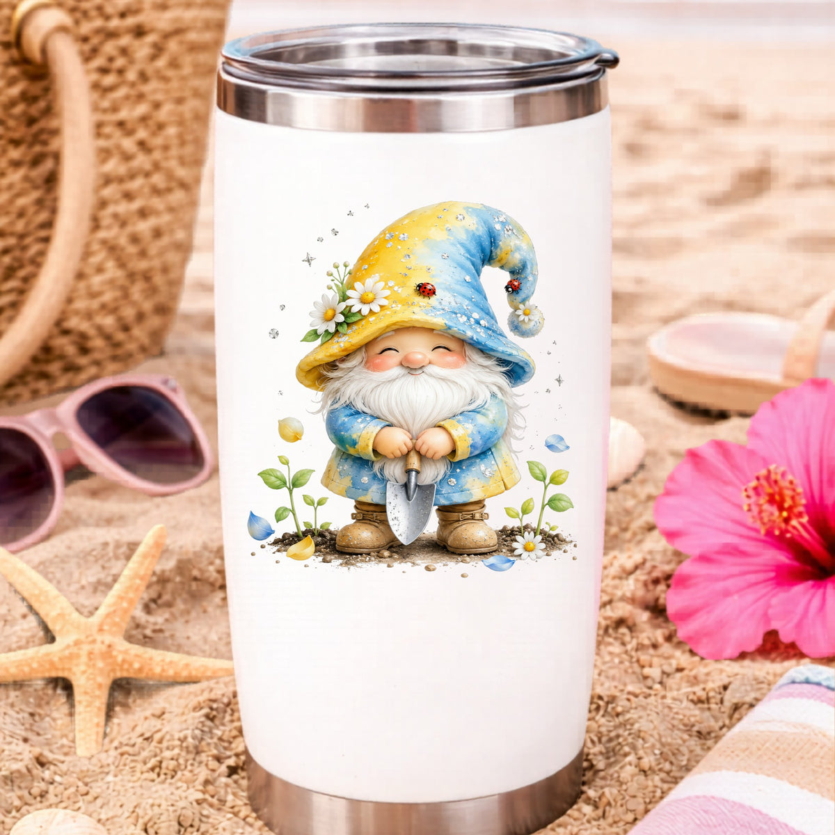 Gardening Gnome With Trowel UV DTF sticker applied to a white travel tumbler on beach sand