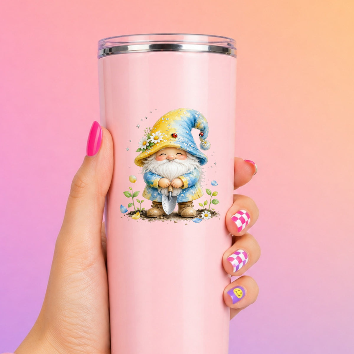 Gardening Gnome With Trowel UV DTF sticker applied to a tall pink tumbler on a pink and orange background