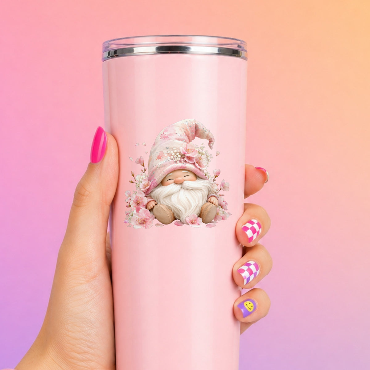 Cherry Blossom Gnome UV DTF sticker applied to a tall pink tumbler on a pink and orange background