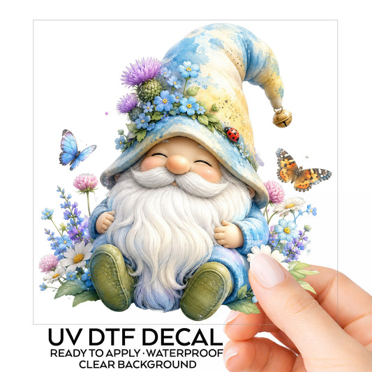 Wildflower Gnome With Butterflies UV DTF sticker on its backing card, held in hand