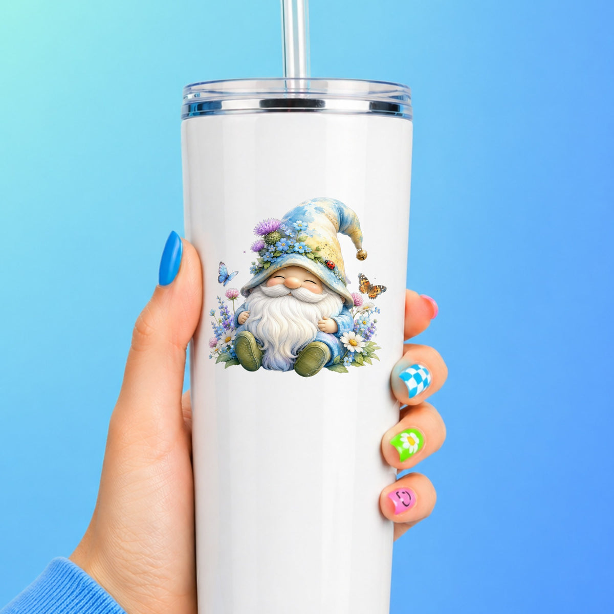 Wildflower Gnome With Butterflies UV DTF sticker applied to a white straw tumbler on a blue background