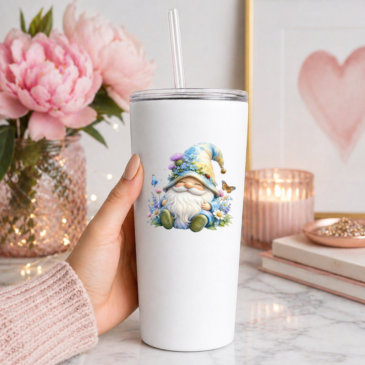 Wildflower Gnome With Butterflies UV DTF sticker applied to a white straw tumbler beside pink peonies