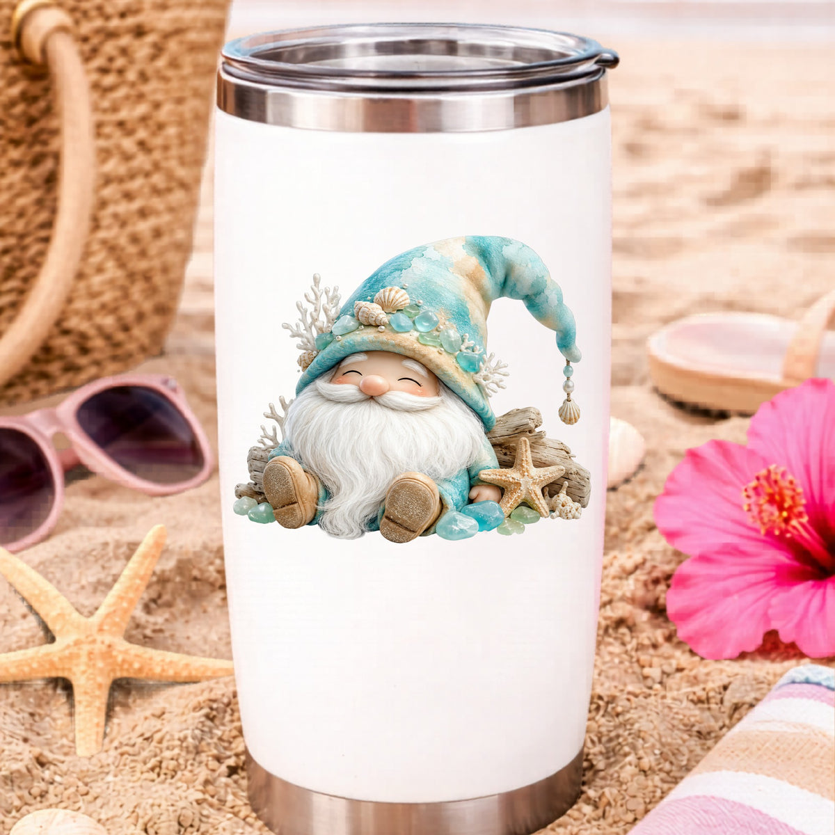Beach Gnome With Seashells UV DTF sticker applied to a white travel tumbler on beach sand