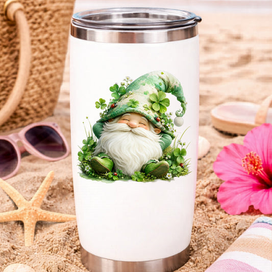 Shamrock Clover Gnome UV DTF sticker applied to a white travel tumbler on beach sand