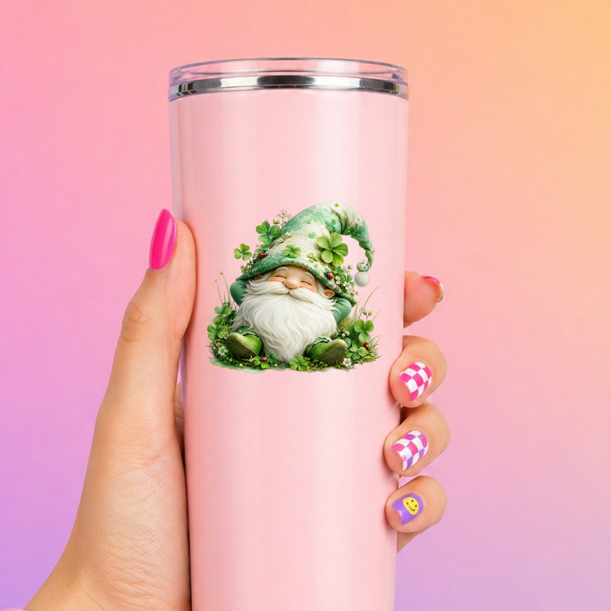 Shamrock Clover Gnome UV DTF sticker applied to a tall pink tumbler on a pink and orange background