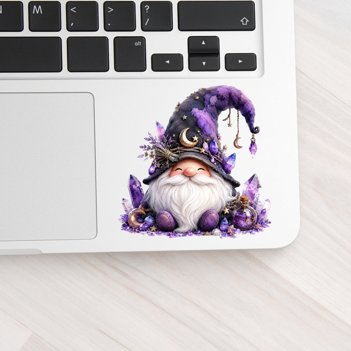 Amethyst Crystal Gnome UV DTF sticker applied to a silver laptop beside the keyboard
