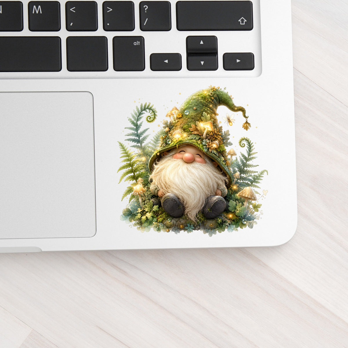 Mossy Forest Gnome UV DTF sticker applied to a silver laptop beside the keyboard