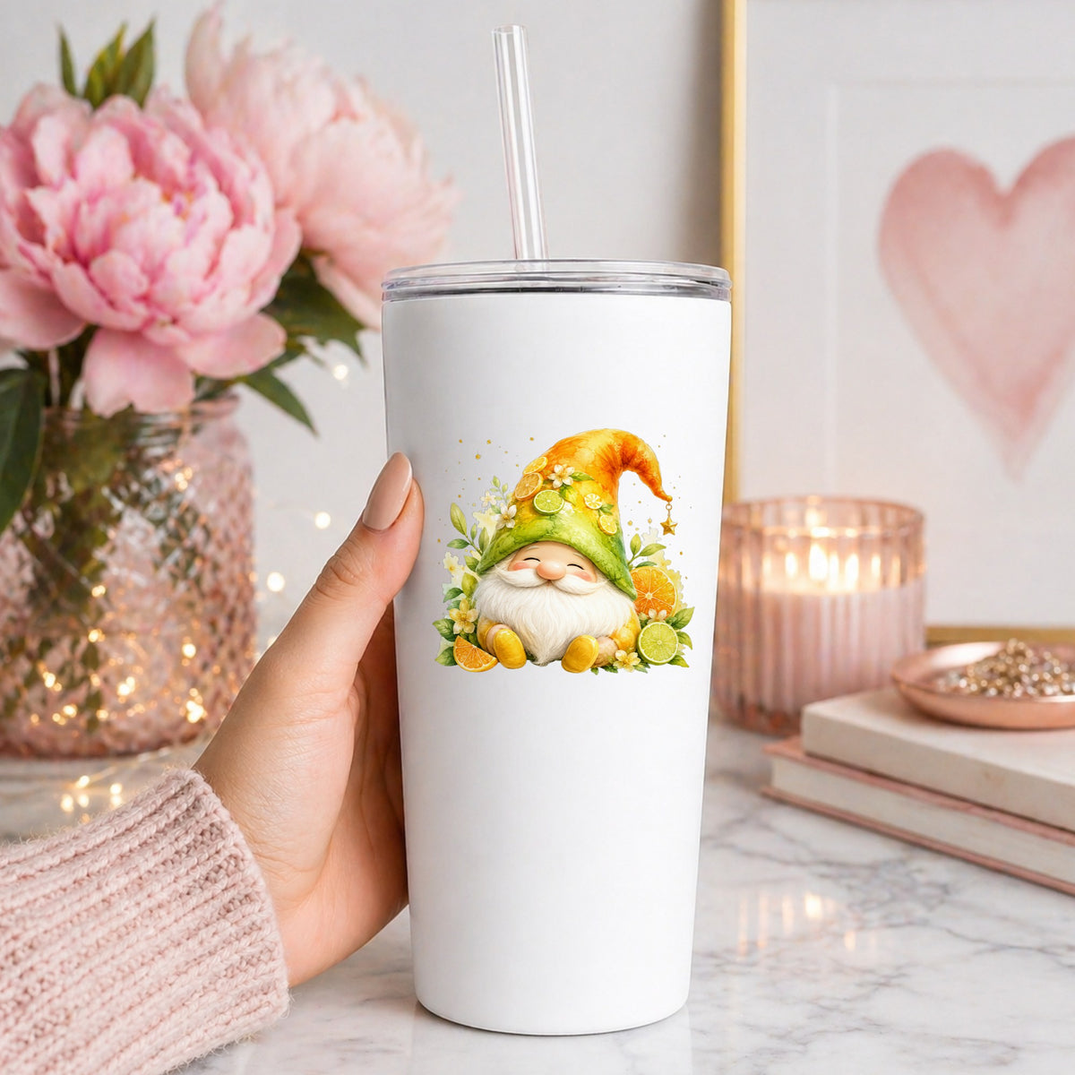 Citrus Gnome With Orange Slices UV DTF sticker applied to a white straw tumbler beside pink peonies