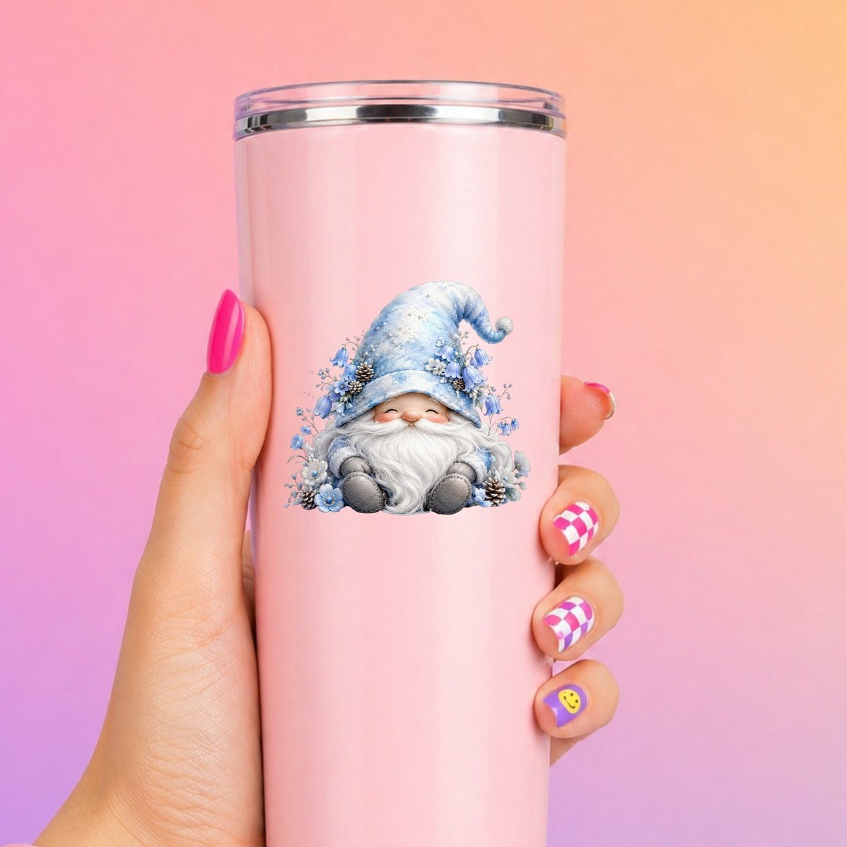 Winter Gnome With Pinecones UV DTF sticker applied to a tall pink tumbler on a pink and orange background