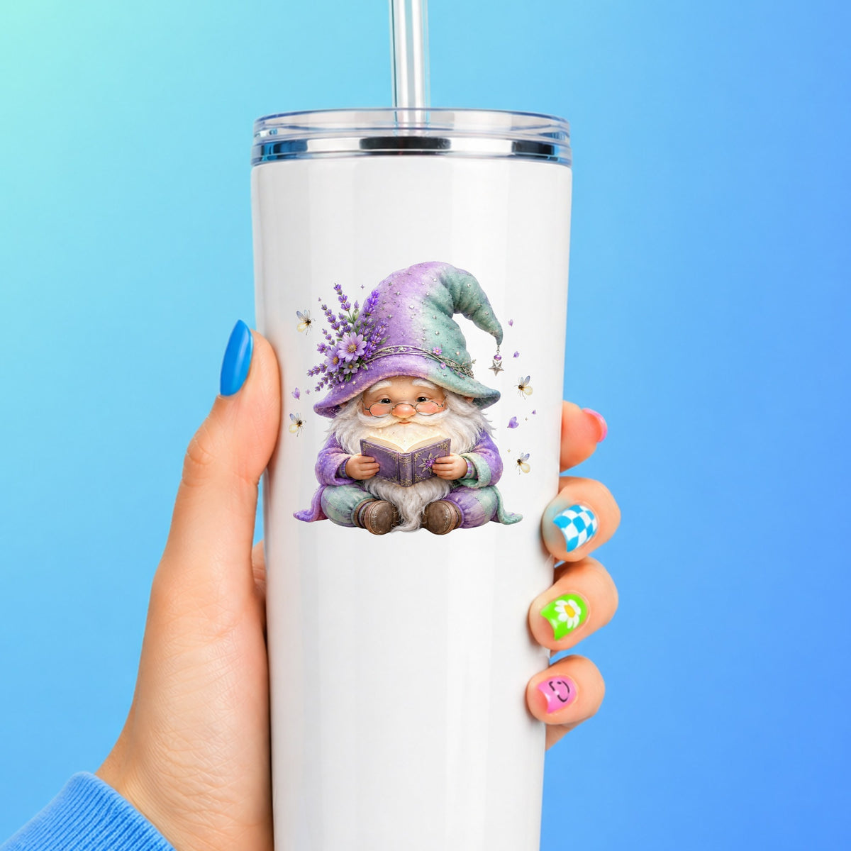 Lavender Reading Gnome With Fireflies UV DTF sticker applied to a white straw tumbler on a blue background