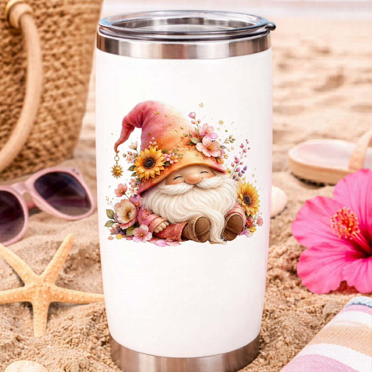 Sunflower Gnome With Pink Flowers UV DTF sticker applied to a white travel tumbler on beach sand