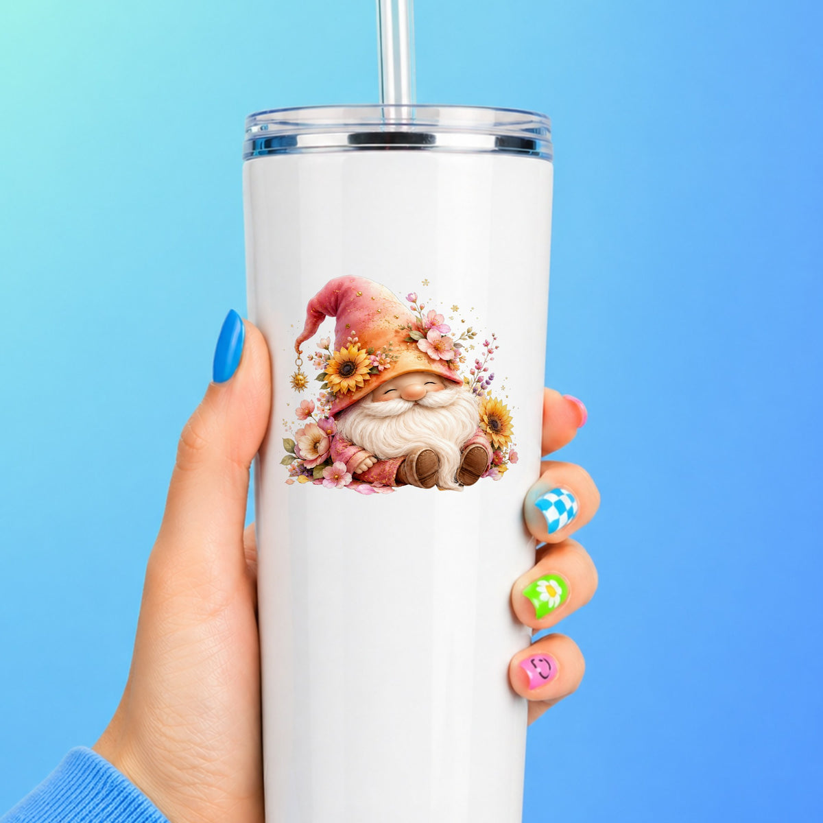 Sunflower Gnome With Pink Flowers UV DTF sticker applied to a white straw tumbler on a blue background