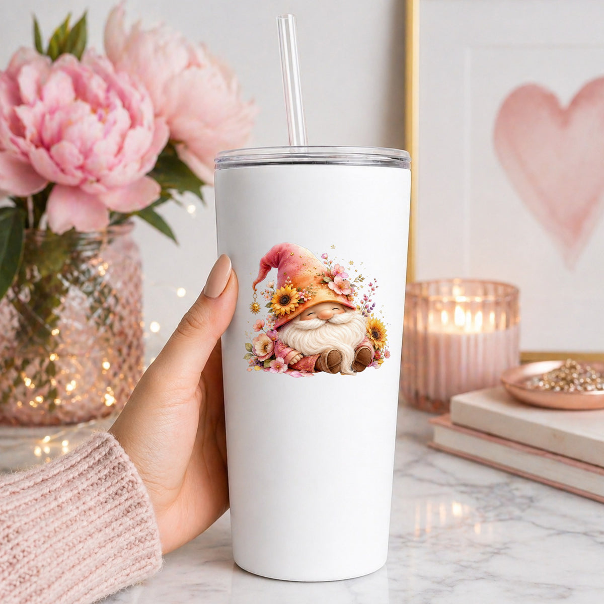 Sunflower Gnome With Pink Flowers UV DTF sticker applied to a white straw tumbler beside pink peonies