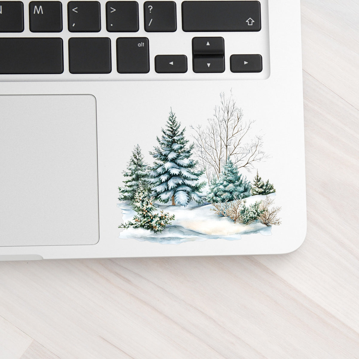 Snow Covered Spruce Trees UV DTF sticker applied to a laptop beside the keyboard