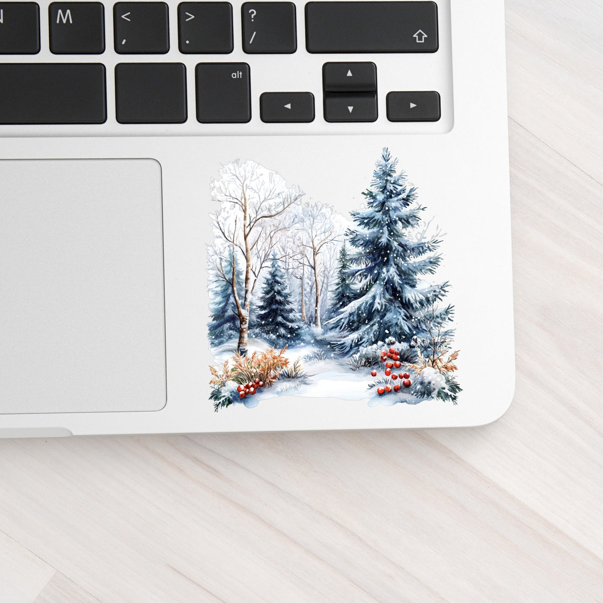 Blue Spruce Winter Forest UV DTF sticker applied to a laptop beside the keyboard