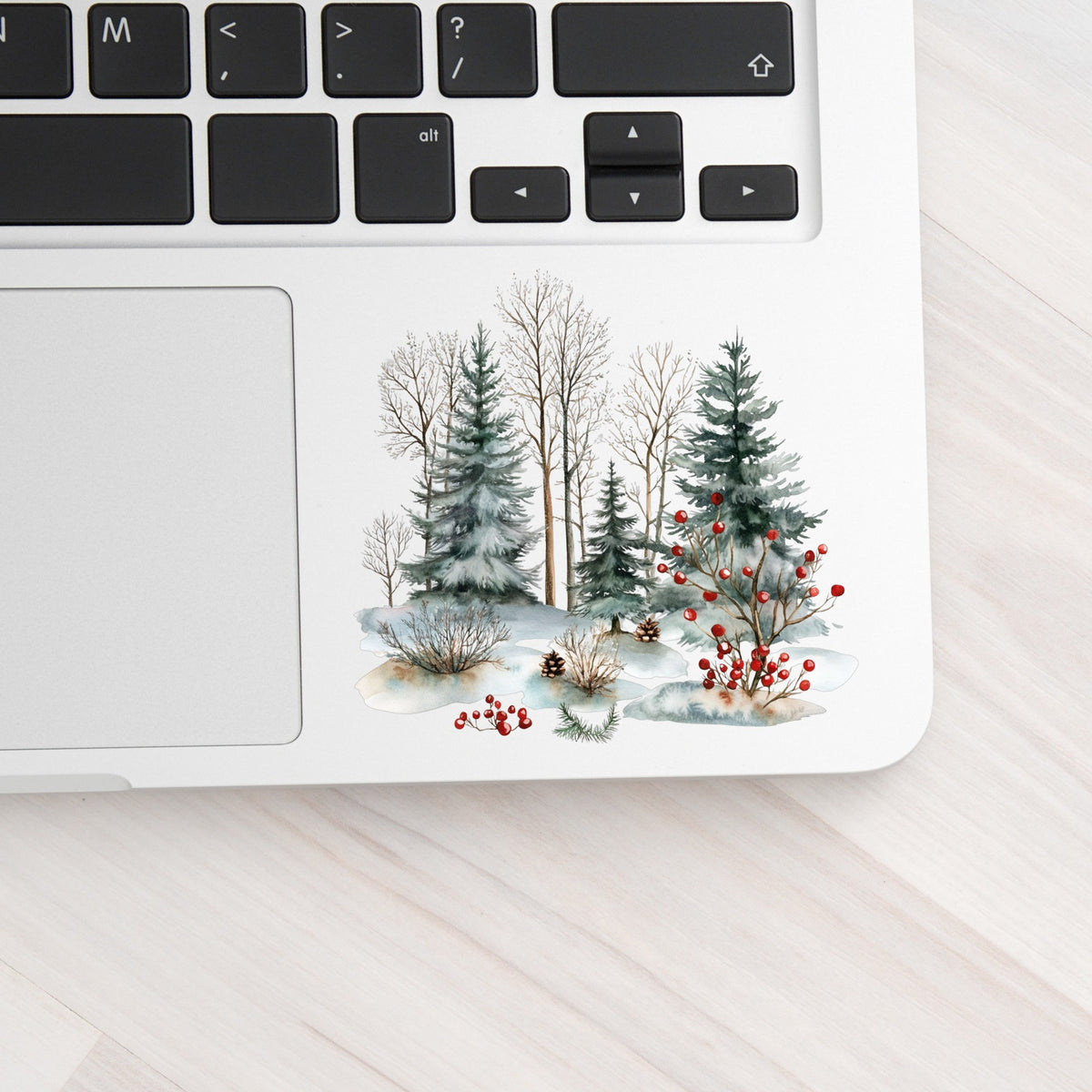 Red Berry Winter Woodland UV DTF sticker applied to a laptop beside the keyboard