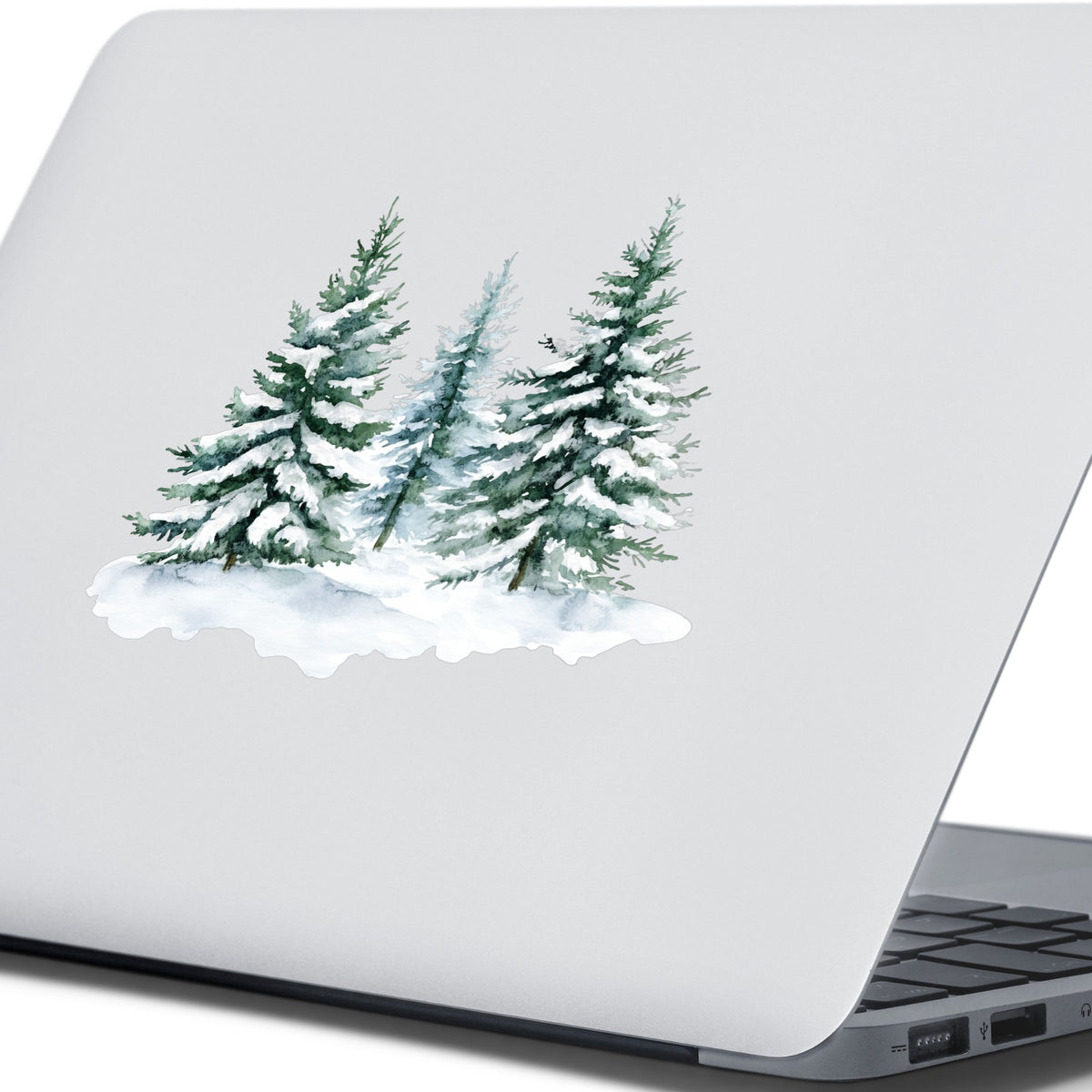 Three Snowy Pine Trees UV DTF sticker applied to a laptop