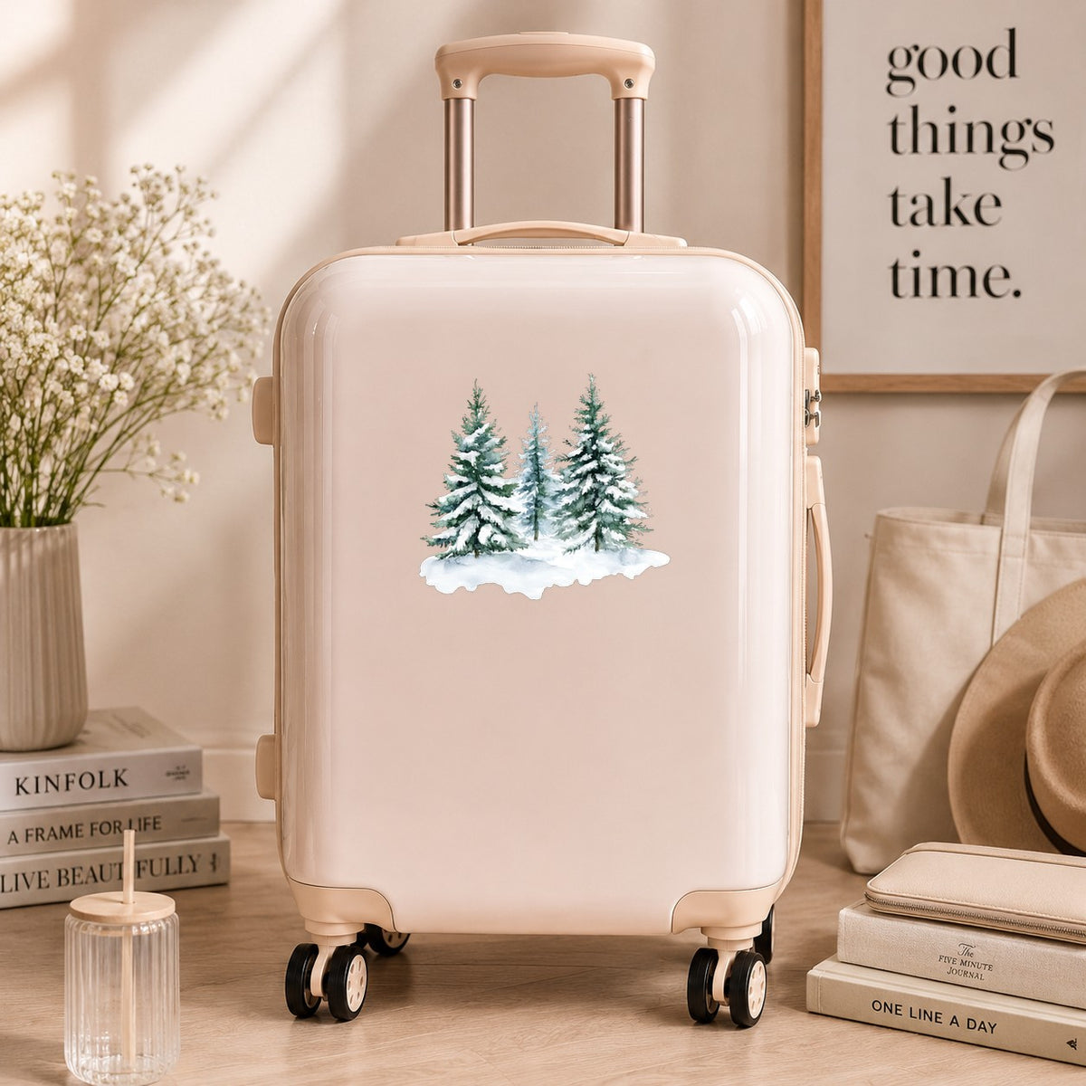 Three Snowy Pine Trees UV DTF sticker applied to a neutral suitcase