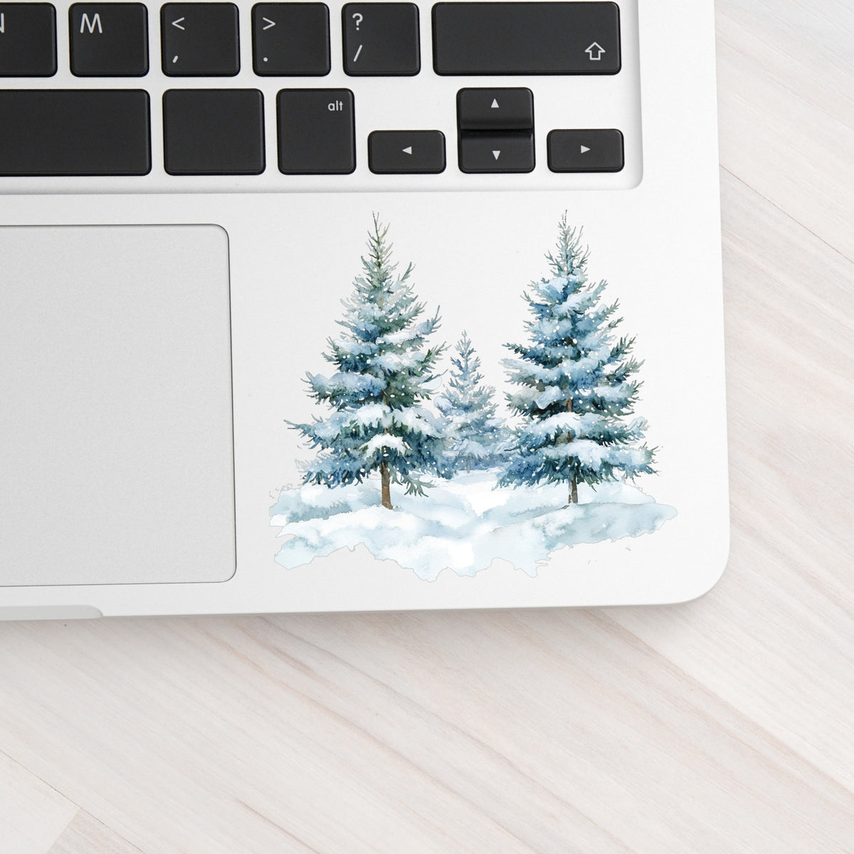 Two Blue Spruce Trees UV DTF sticker applied to a laptop beside the keyboard