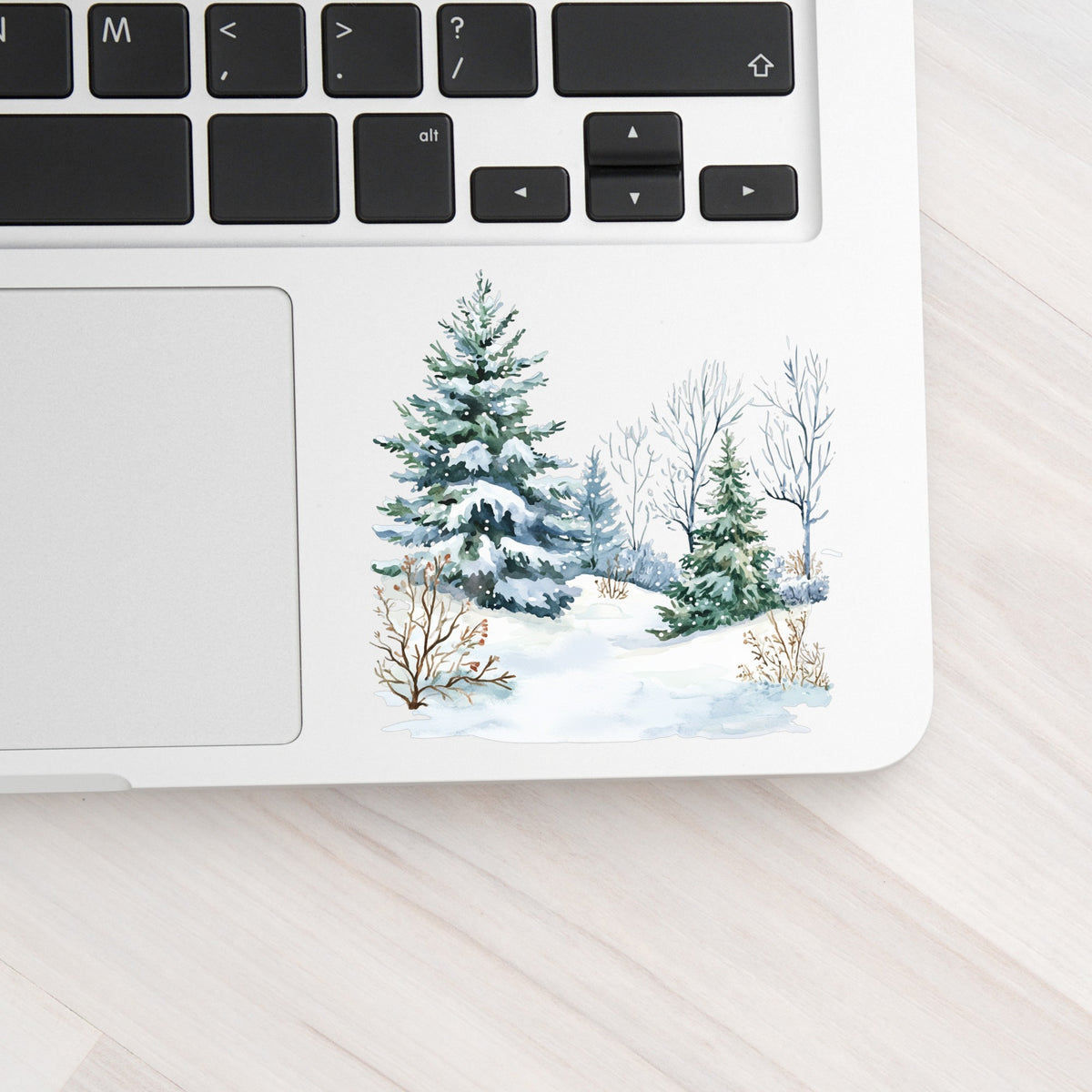 Winter Spruce Grove UV DTF sticker applied to a laptop beside the keyboard