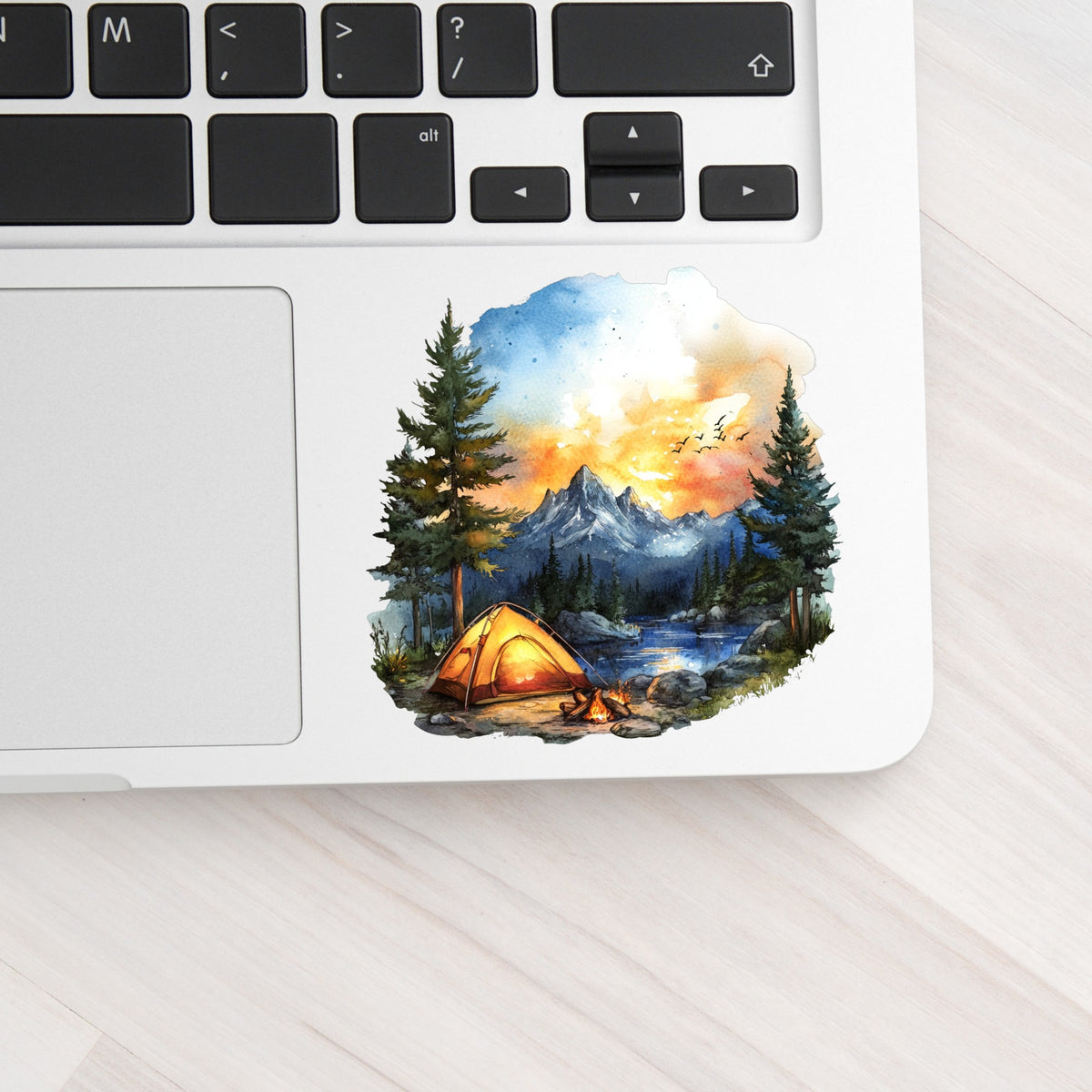 Sunset Mountain Campfire UV DTF sticker applied to a laptop beside the keyboard