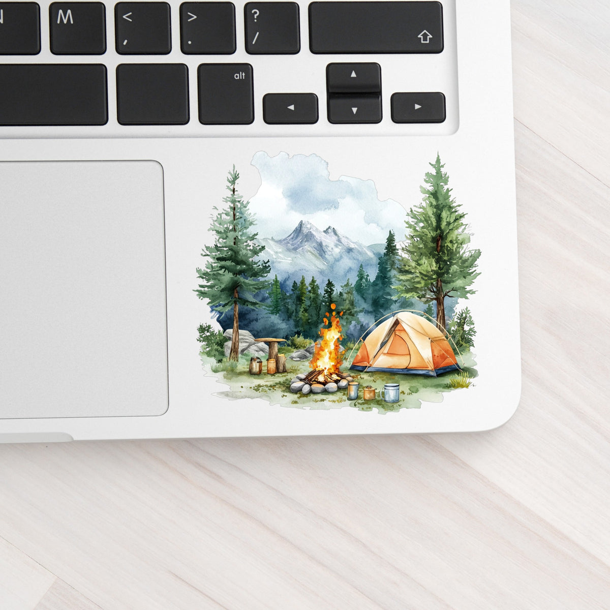 Campfire And Tent With Mugs UV DTF sticker applied to a laptop beside the keyboard