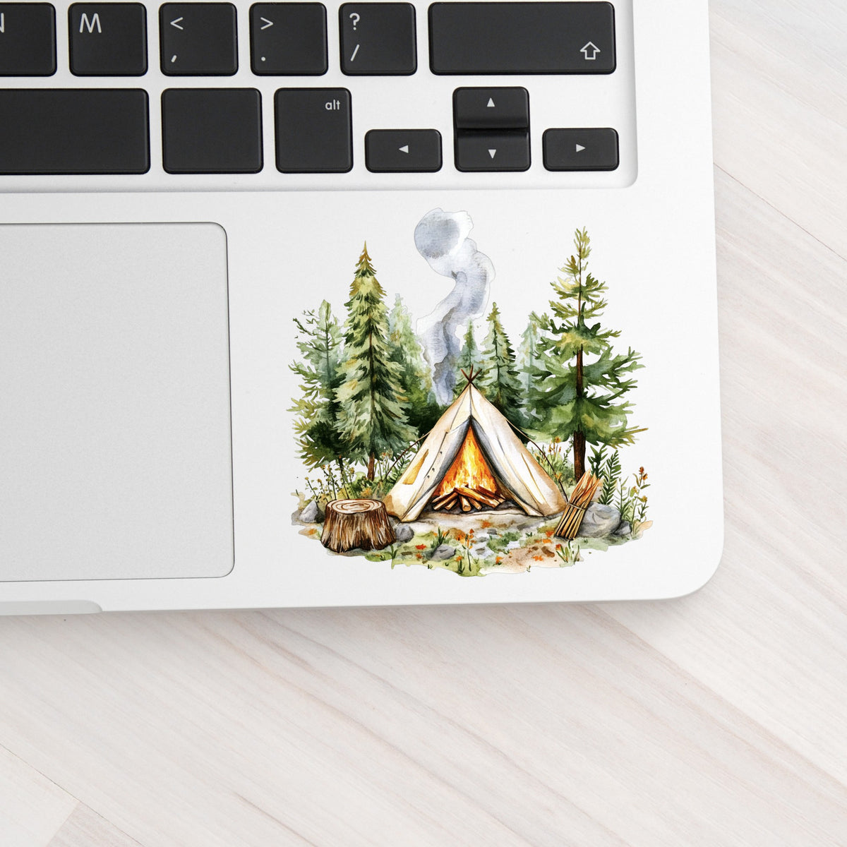 Canvas Teepee With Campfire UV DTF sticker applied to a laptop beside the keyboard