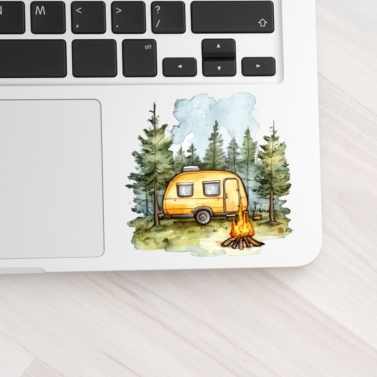 Yellow Camper Trailer UV DTF sticker applied to a laptop beside the keyboard