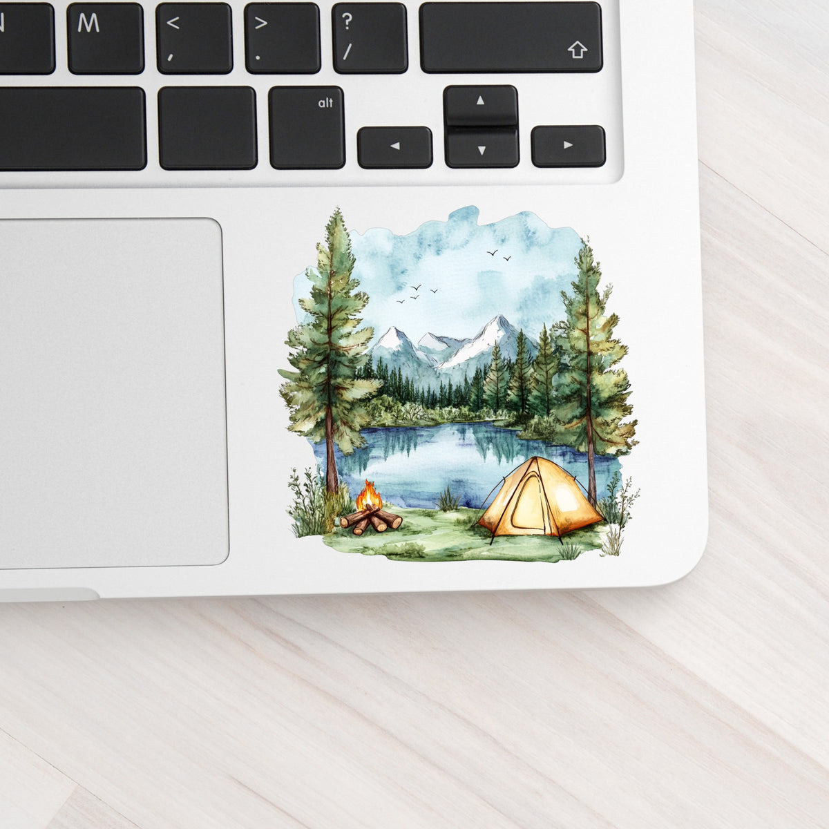 Lake Campfire And Tent UV DTF sticker applied to a laptop beside the keyboard