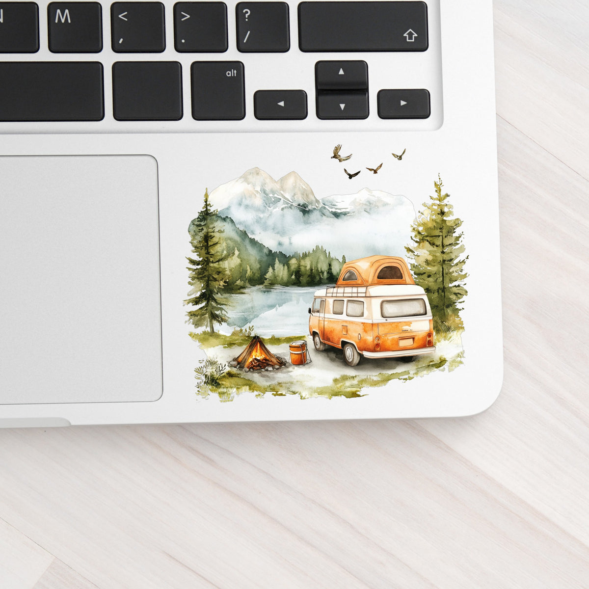 Orange Camper Van UV DTF sticker applied to a laptop beside the keyboard