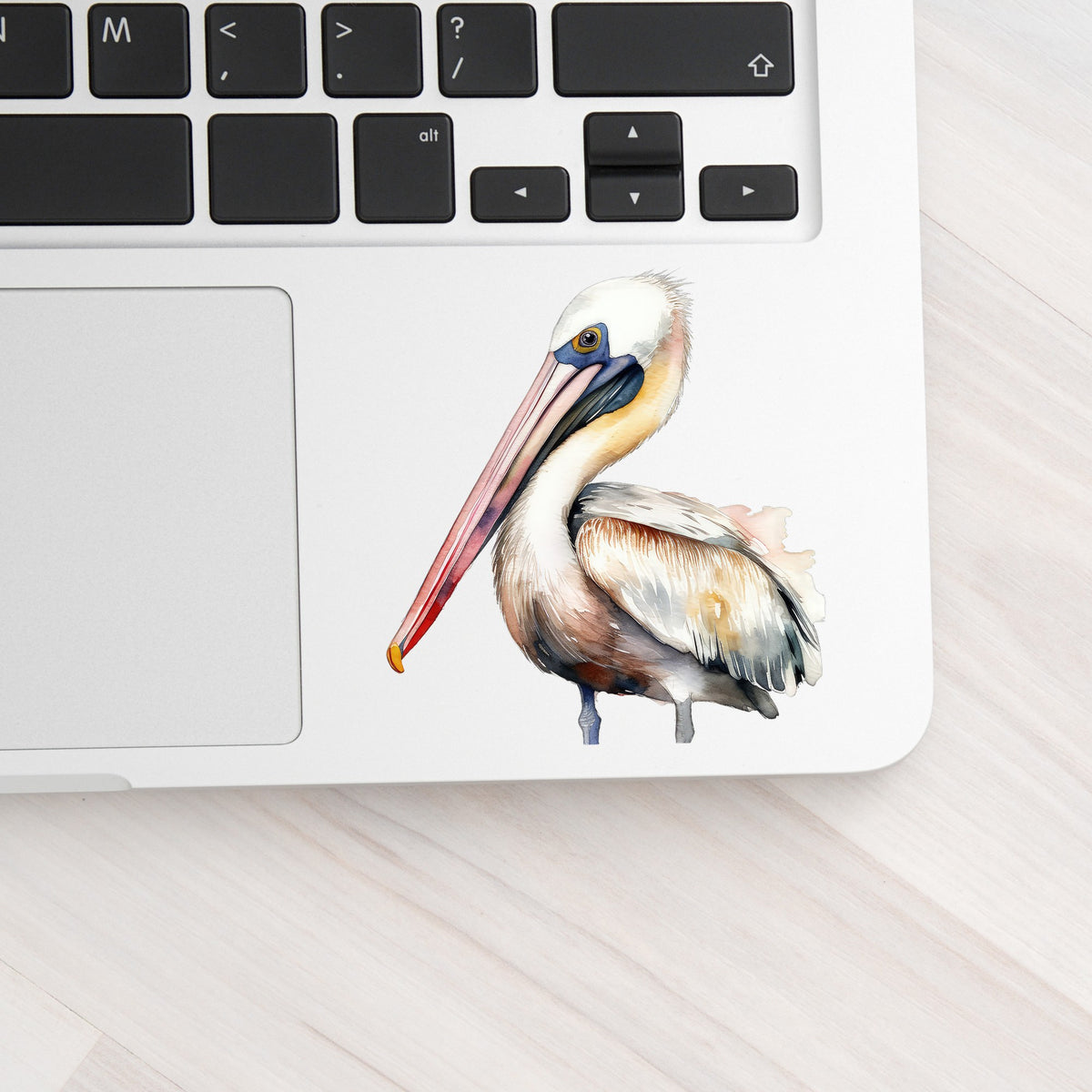 Pink Beak Pelican UV DTF sticker applied to a laptop beside the keyboard