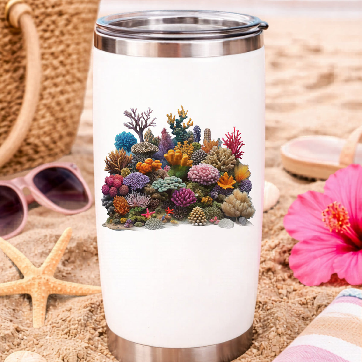 Colorful Coral Reef UV DTF sticker applied to a white travel tumbler on beach sand
