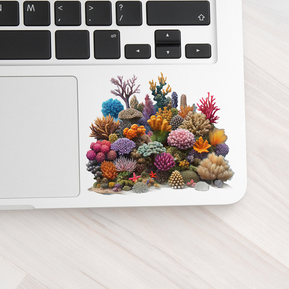 Colorful Coral Reef UV DTF sticker applied to a silver laptop beside the keyboard