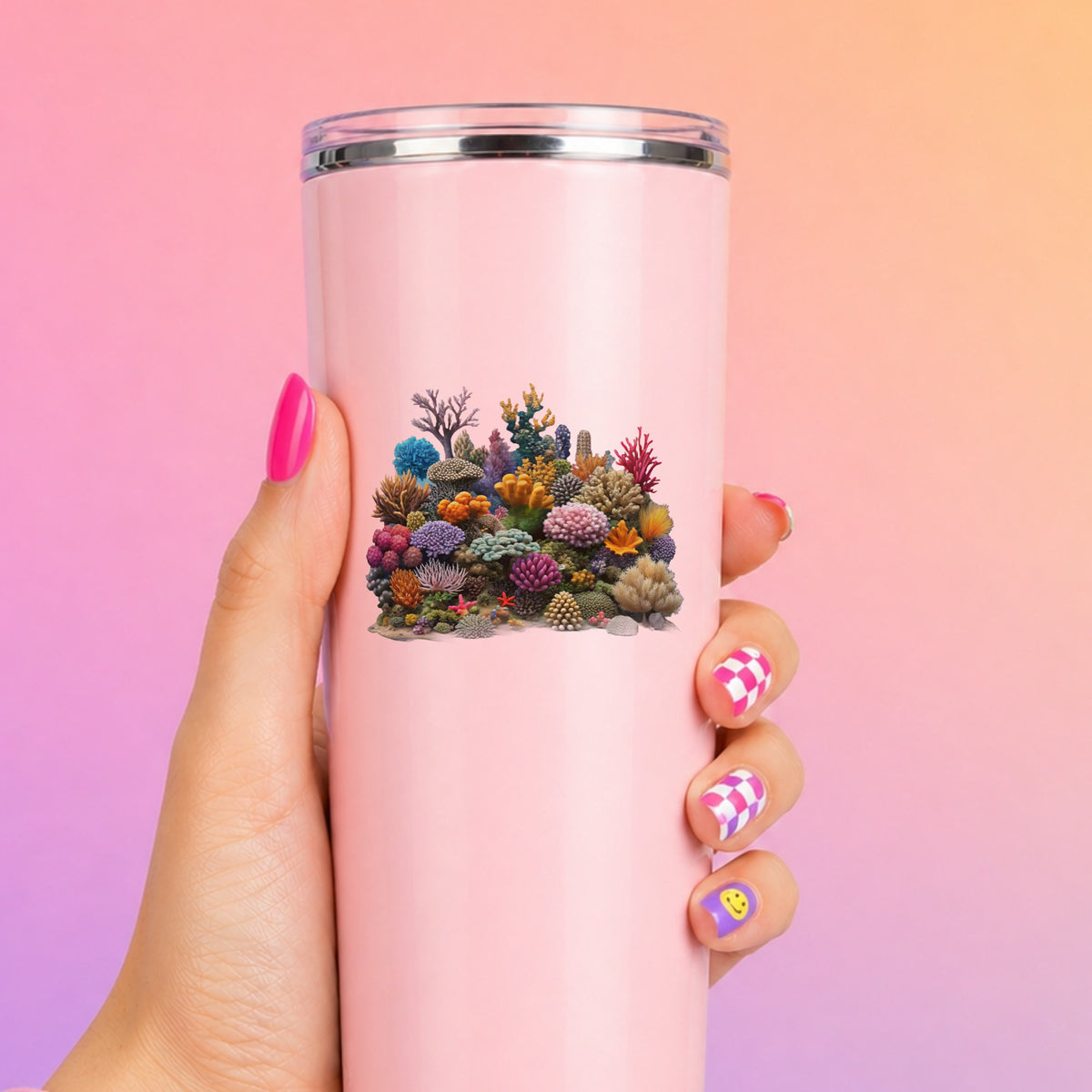 Colorful Coral Reef UV DTF sticker applied to a tall pink tumbler on a pink and orange background