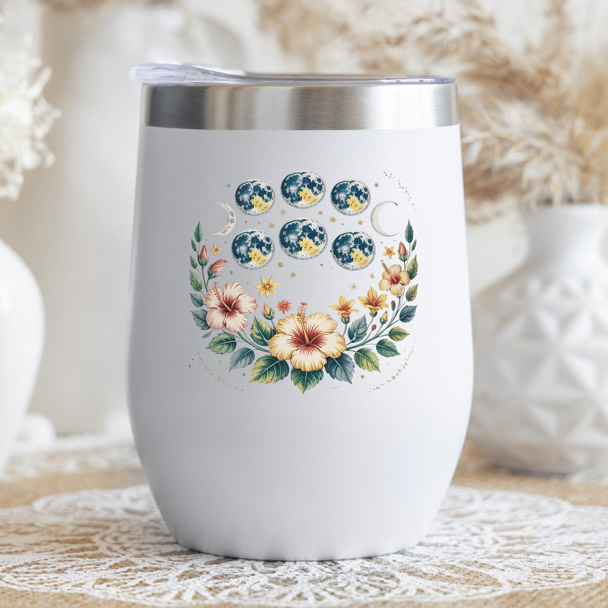 Moon Phases With Hibiscus Flowers UV DTF sticker applied to a white stemless tumbler with a lid